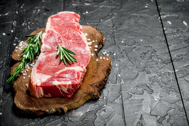 Raw beef steaks with fragrant rosemary