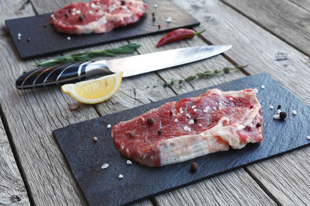 Raw beef steaks on wooden table