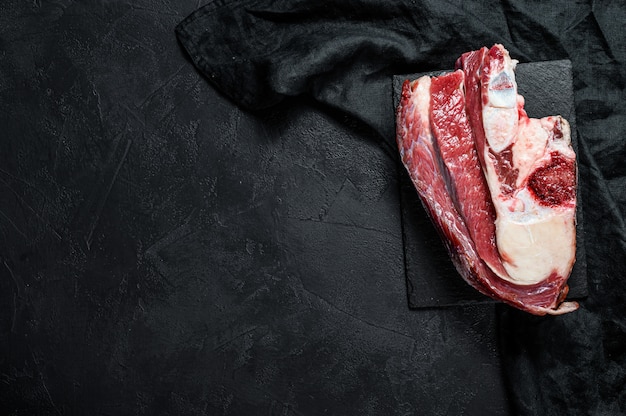 Raw beef with bone on black background