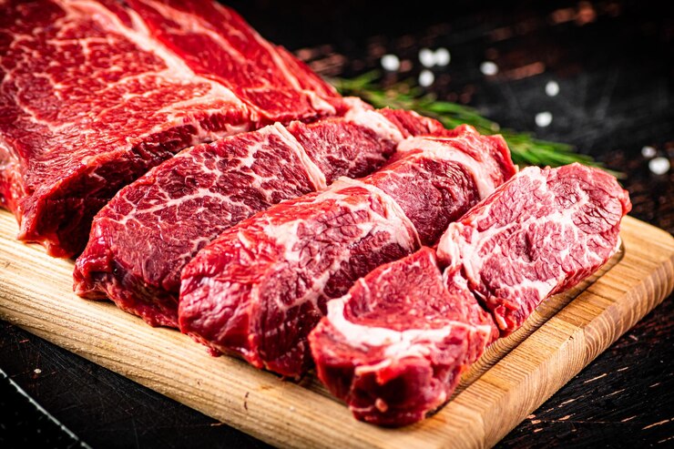 로즈마리와 함께 나무 커팅 보드에 원시 쇠고기