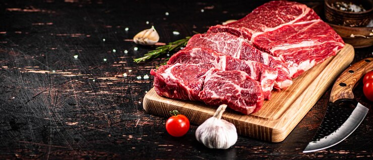 로즈마리와 함께 나무 커팅 보드에 원시 쇠고기