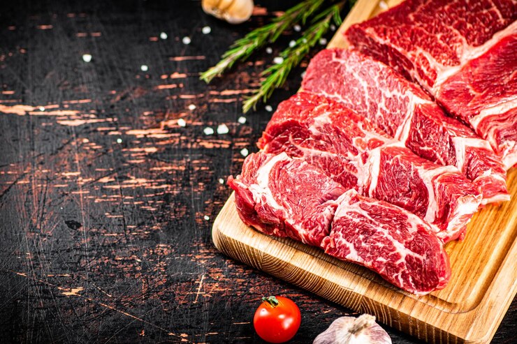 로즈마리와 함께 나무 커팅 보드에 원시 쇠고기