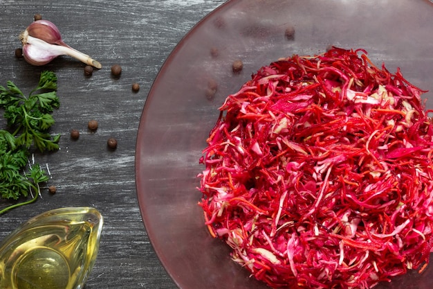 Raw beetroot, carrot and cabbage salad on the black background