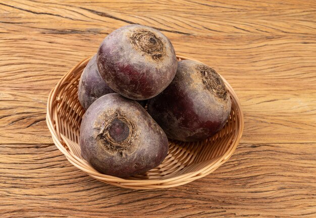 Raw beetroots in a basket over wooden table