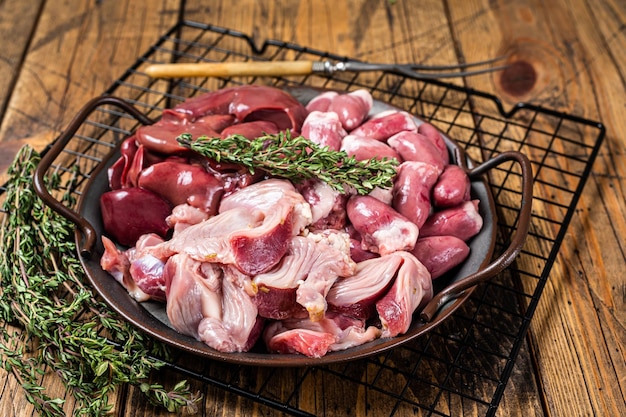 Raw bird giblets meat set chicken offals liver hearts gizzards Stomach Wooden background Top view