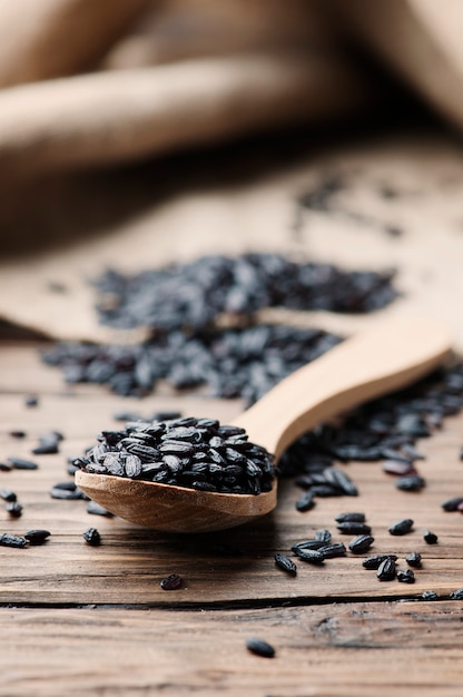 Raw black rice on the wooden table