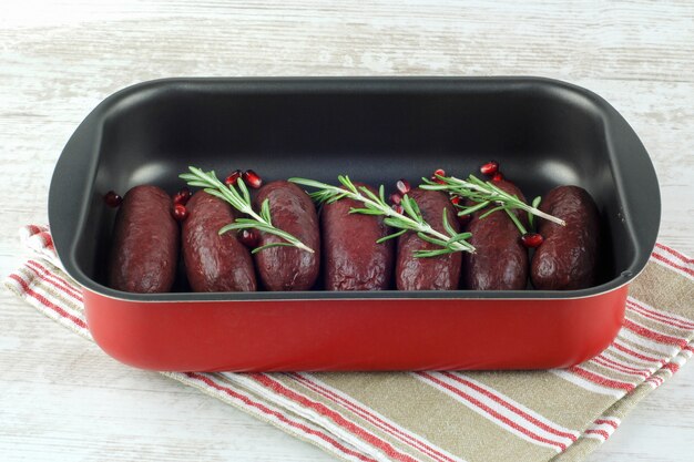 Raw blood sausages in baking dish