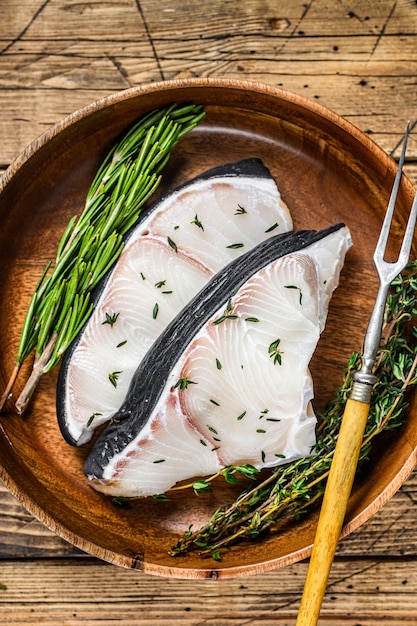 Raw Blue Shark steaks in a wooden plate.