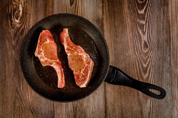 Raw bone in steak on the pan skillet