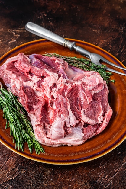 Raw Boneless Lamb leg meat in rustic plate with thyme