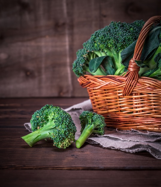 Raw broccoli in a brown wicker basket 