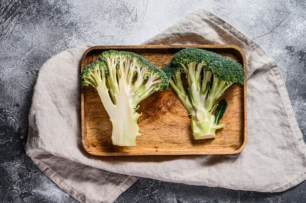 Raw broccoli halves in a wooden bowl. 