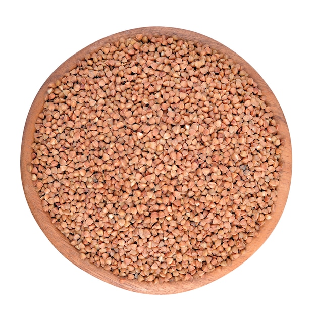 Raw buckwheat in a wooden bowl isolated on a white background