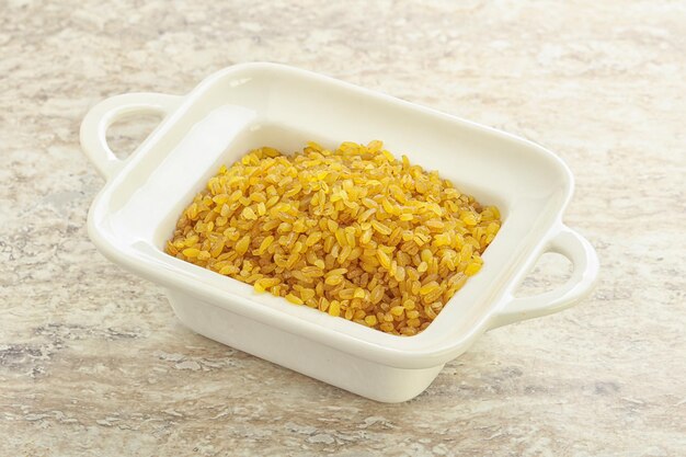 Raw bulgur in the bowl for cooking