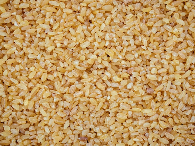 Raw bulgur wheat grain texture as background. Healthy, dietary, vegan, gluten free product. Healthy eating concept. Organic product made from wheat grains. Natural protein, fiber and fat. Top view.