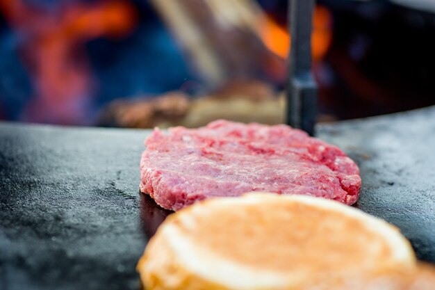 Raw burger beef patties on the grill Open fire on the barbecue