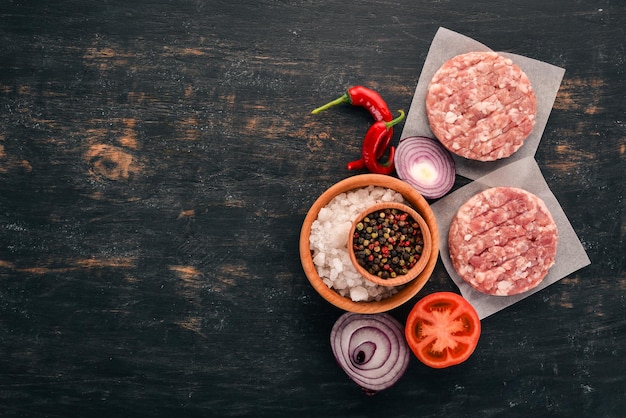 Raw burger On a black wooden background Top view Free copy space