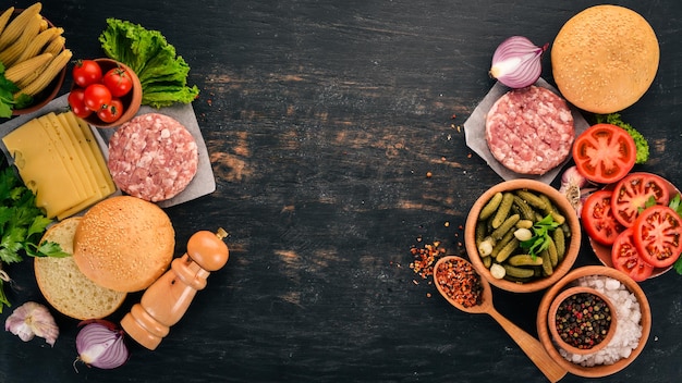 Raw burger Cooking a burger with meat On a black wooden background Top view Free copy space