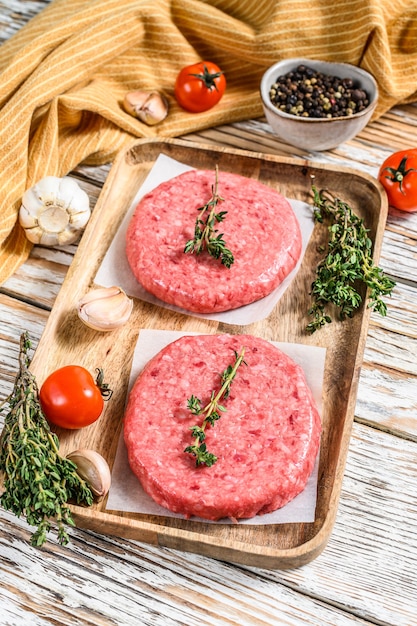 Raw Burger patties. Mince meat cutlet, ground beef and pork.  White background. Top view.