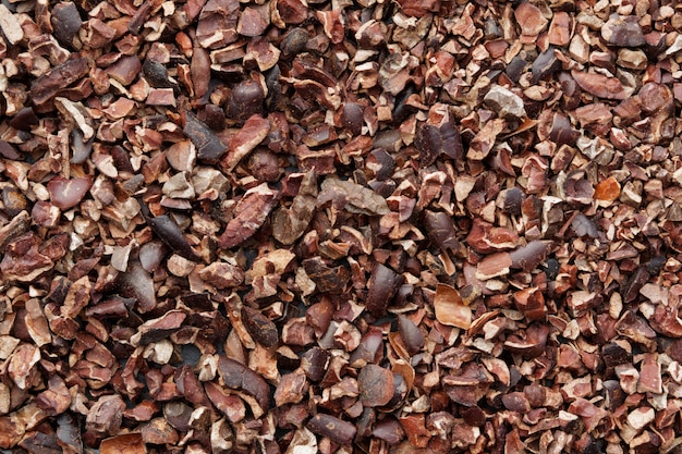 Raw Cacao nibs background. Top view.