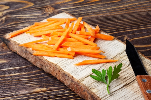 Raw carrot sticks on a cutting board