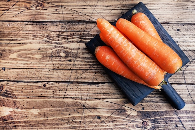 raw carrots on a wooden rustic board