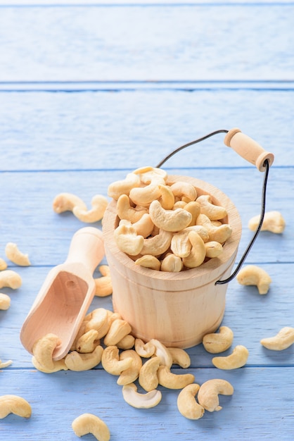 raw cashew nuts in bucket on blue wood table