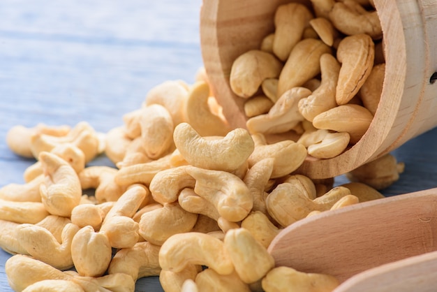 raw cashew nuts in wood bucket on blue wood table