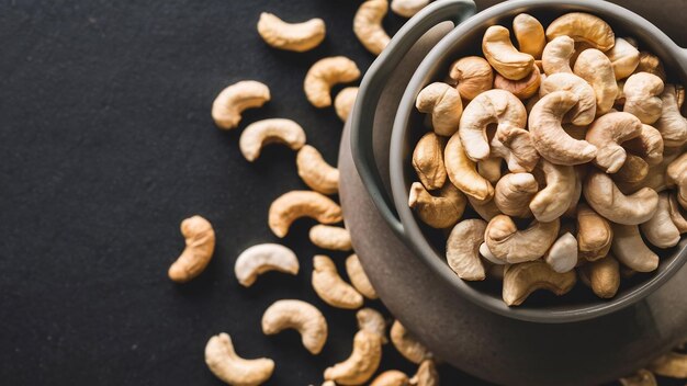 Raw cashews nuts in bowl on dark background