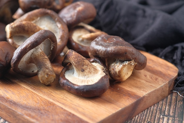 Raw champignon mushroom on a chopping board on table .