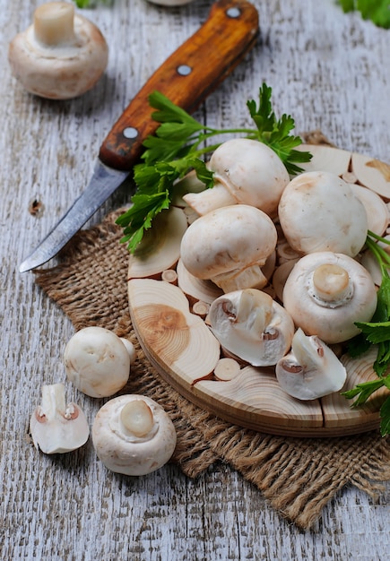 Raw champignon mushroom on wooden background 