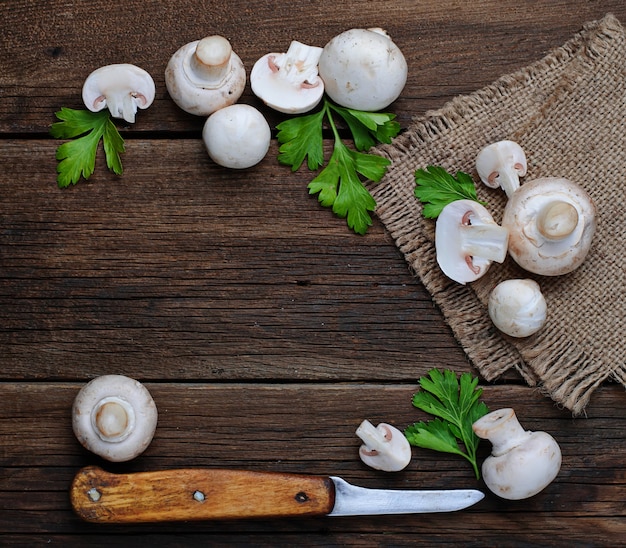 Raw champignon mushroom on wooden background 