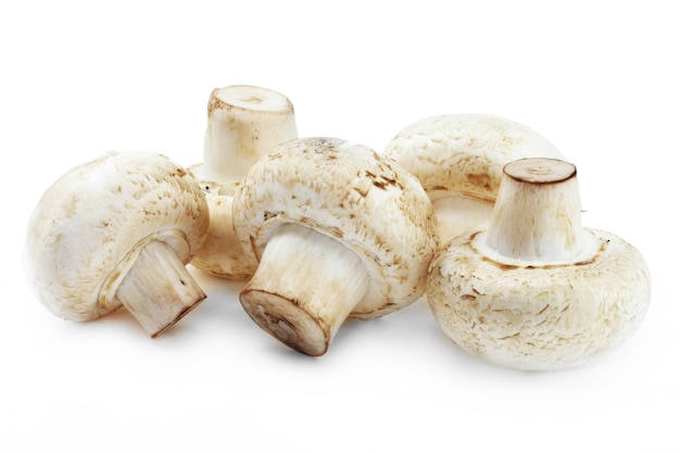Raw champignon mushrooms on a white background