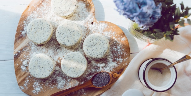 Raw cheese cakes with poppy seeds on a wooden surface. with ingredients