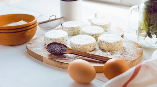 Photo raw cheese cakes with poppy seeds on a wooden surface