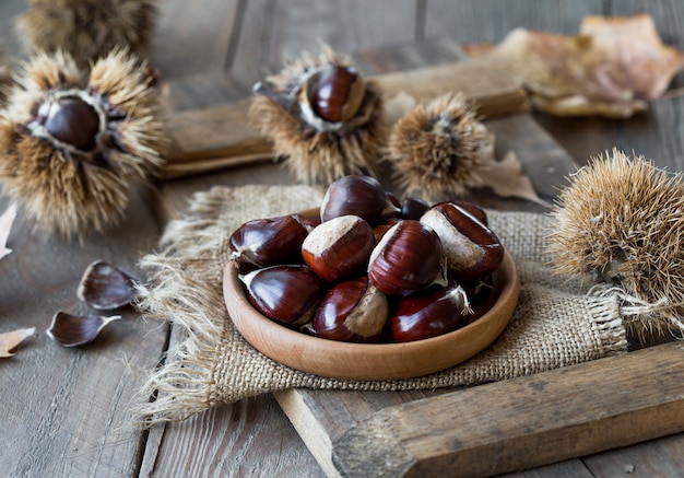 raw chesnuts in wooden bowl