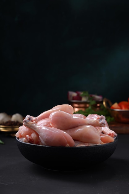 Raw chicken biriyani cut without skin arranged on black container