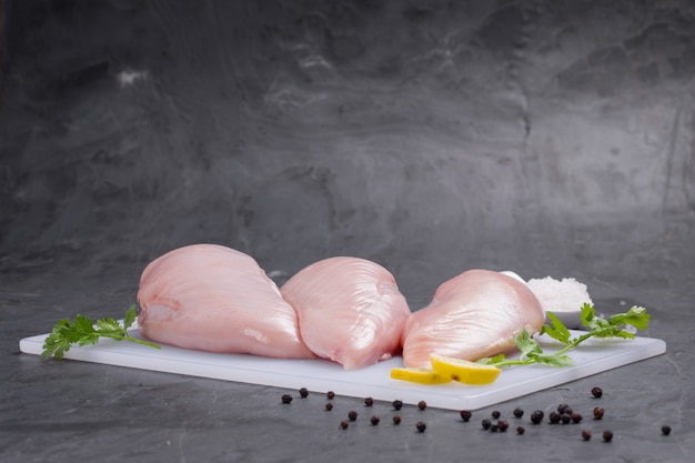 Raw chicken breast fillet without skin arranged on board