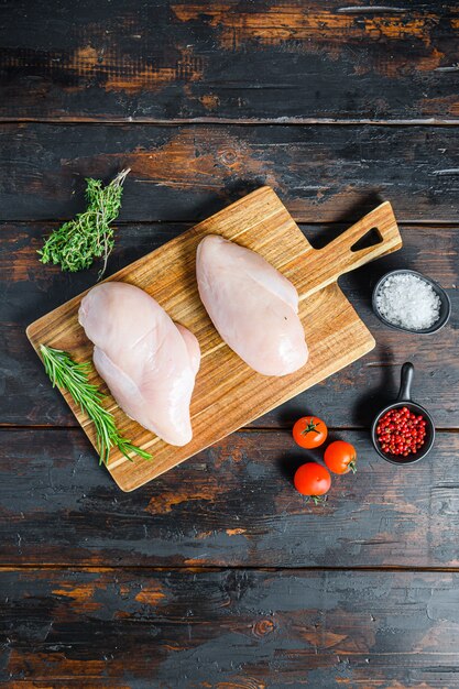 Photo raw chicken breast fillets and vegetable on chopping board