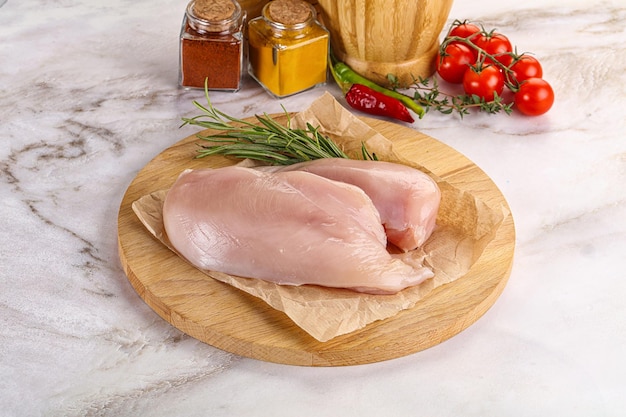 Raw chicken breast served rosemary for cooking