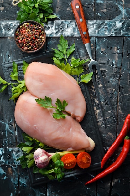 Raw chicken breast with parsley and spices on the table Top view Free space for your text Rustic style