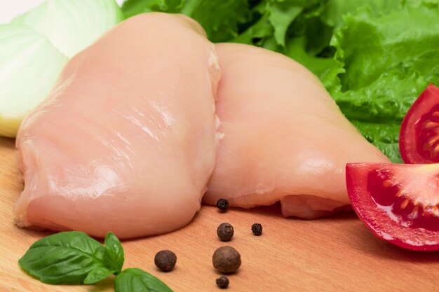 The Raw chicken breasts on cutting board