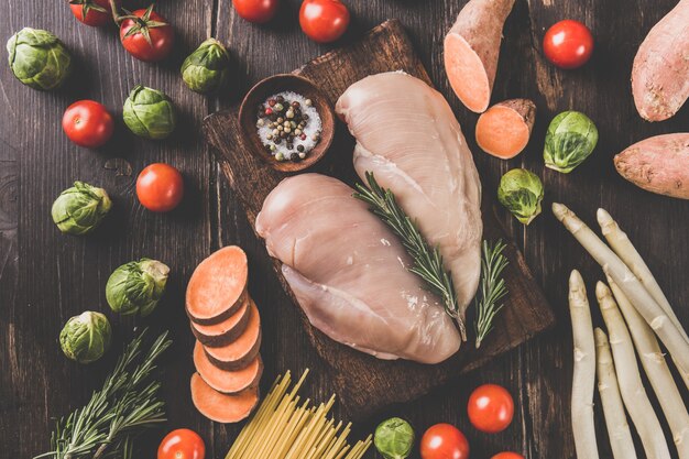 Photo raw chicken breasts and vegetables