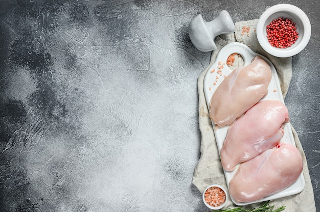 Photo raw chicken breasts on a white chopping board