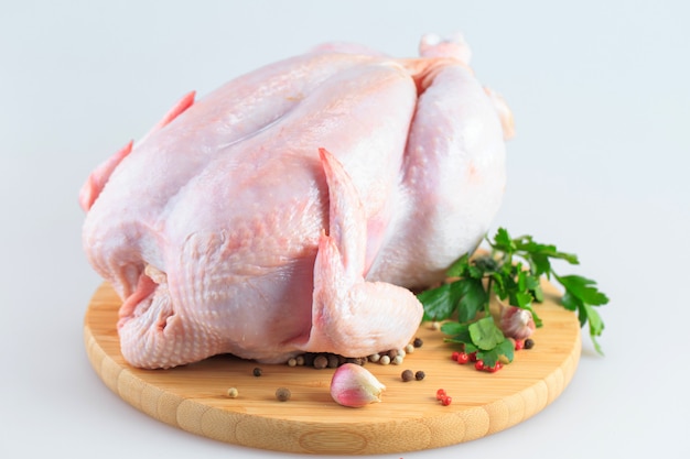 Raw chicken carcass on the cutting board isolated on white background