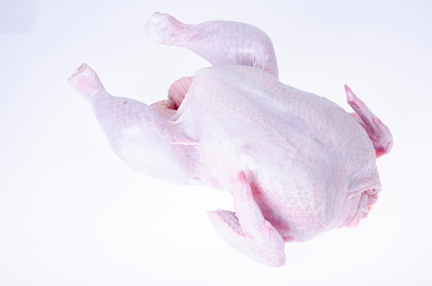 Raw chicken carcass with skin isolated on white .