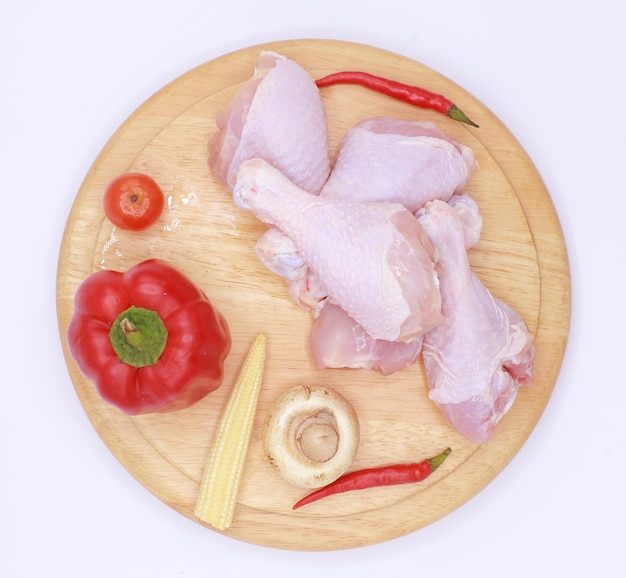 Photo raw chicken on a cutter board with vegetables and spices