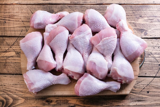 Photo raw chicken drumstick on a cutting board chicken meat for cooking top view