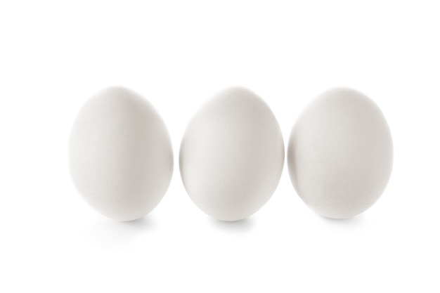 Фото Сырые куриные яйца на белой стене