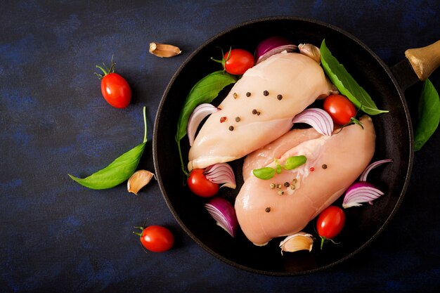 Foto filetto di pollo crudo preparato per la cottura in padella su un tavolo scuro. vista dall'alto